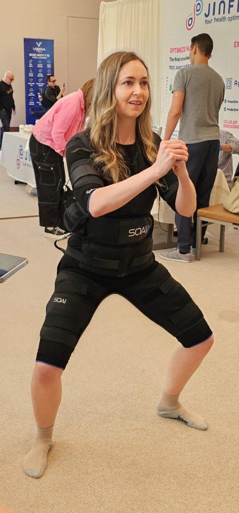 The SQAI Power Suit (pictured here) sends electrical impulses to muscles. Here, a woman squats as she wears it.