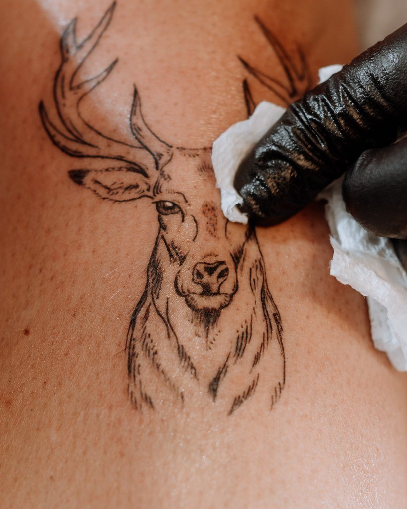 Tattoo artist at work, tattooing a design onto a person