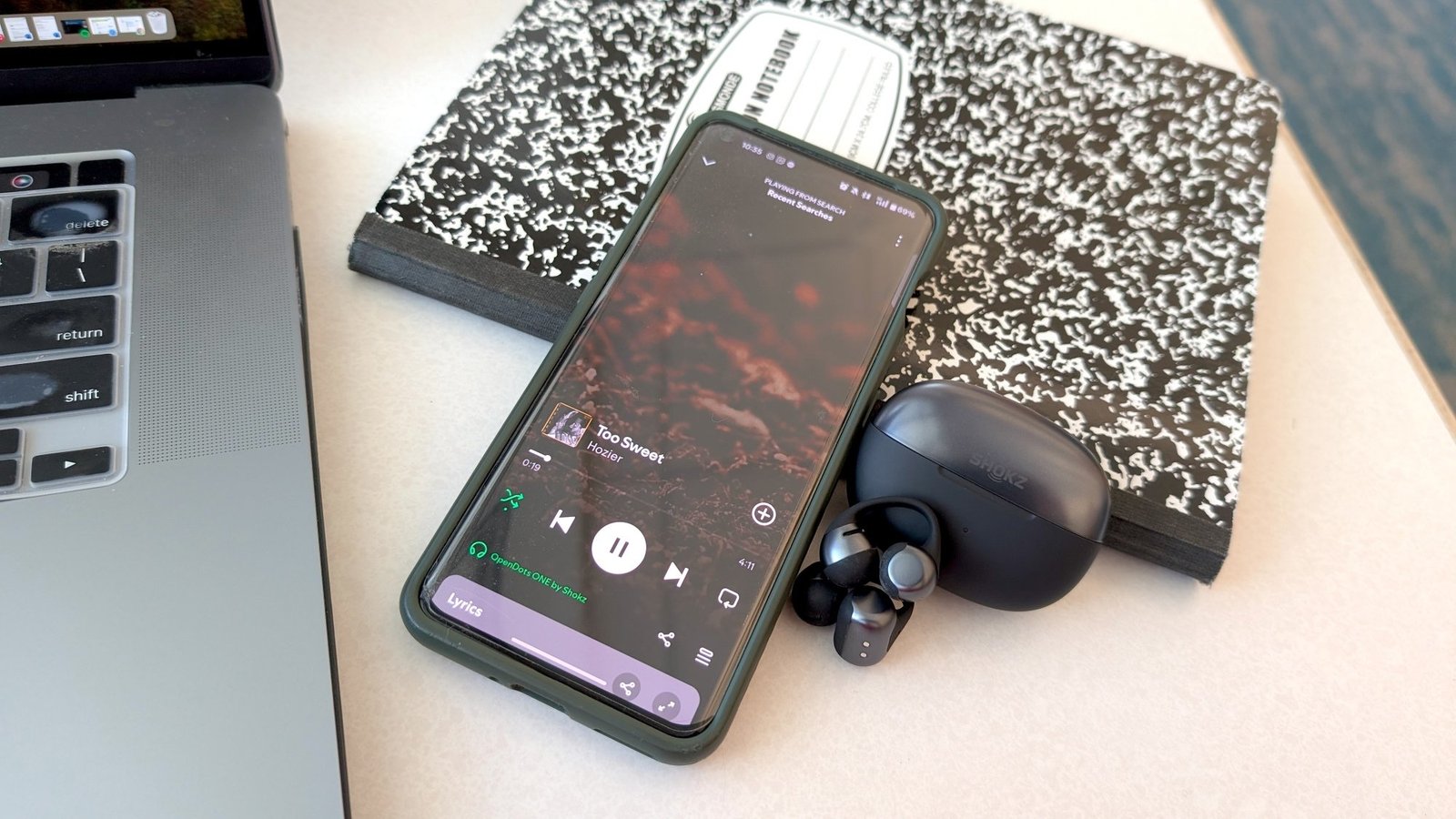 shokz opendots one earbuds next to phone with Hozer