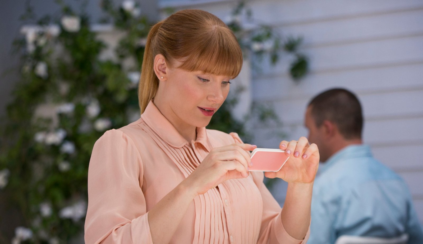 A woman stares at her phone.